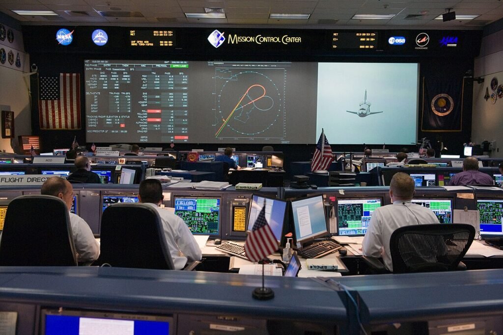 Flight controllers working at consoles in NASA Mission Control